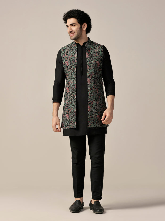 The model is standing confidently, posing in Kisah Black Silk Blend Printed Jacket Kurta Trouser Set