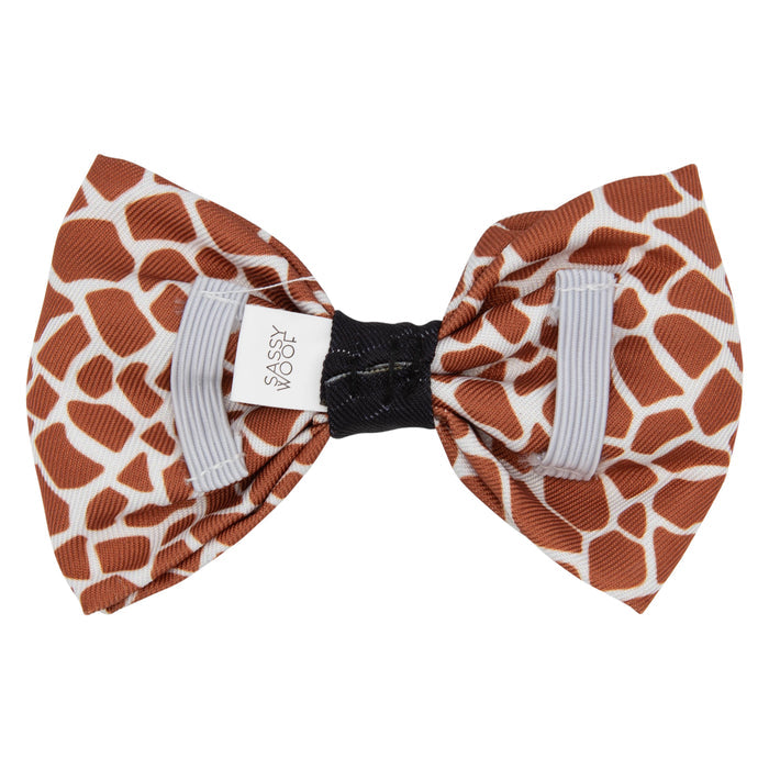 The Sassy Woof Dog Bowtie - Giraffic Park features a brown and white giraffe print, gathered with a black band and white ribbons. Pair it with an adjustable harness and matching leash for a perfectly coordinated look.