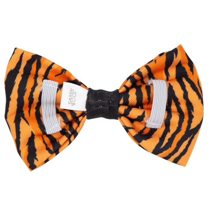 The Sassy Woof Dog Bowtie - Paw of the Tiger features orange and black tiger stripes, a white fabric label, and elastic bands for easy attachment—ideal to pair with an adjustable harness.