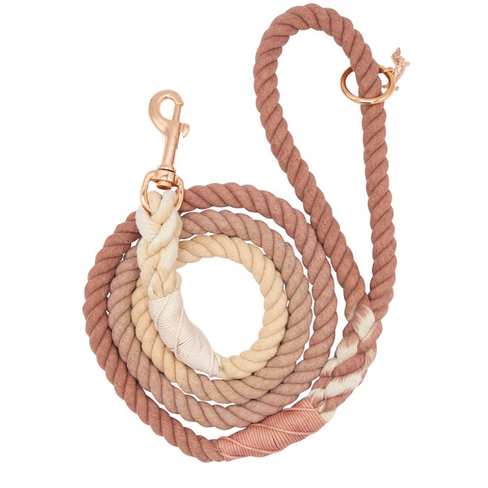 The Sassy Woof Dog Rope Leash - Pearly is a hand-crafted cotton leash in ombre tan, beige, and cream with a rose gold metal clip and O-ring, shown coiled loosely on a white background.