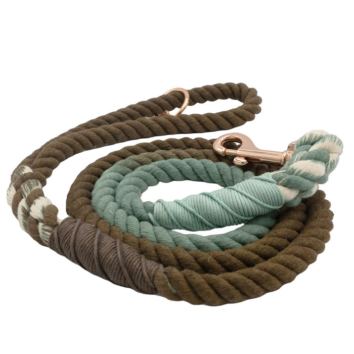 The Sassy Woof Dog Rope Leash - Tail Mix is a hand-dyed, two-toned cotton leash in brown, green, and cream, featuring reinforced ends and a metal clasp for secure collar attachment.