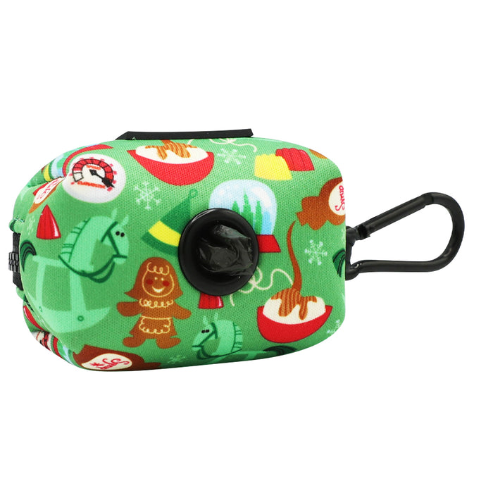 The Sassy Woof Dog Waste Bag Holder - Elf™ is a green rectangular neoprene dispenser with a black clip, featuring cartoon holiday designs like gingerbread men, cacti in Santa hats, and hot chocolate mugs. A black bag peeks from its opening.