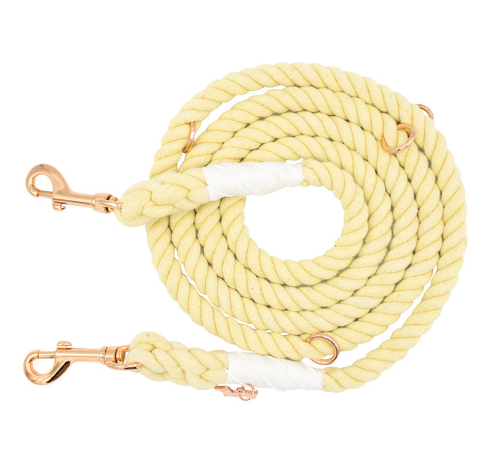 The Sassy Woof Hands-Free Rope Leash - Dandelion is a thick, cream-colored coiled rope dog leash featuring gold metal clips at both ends and white tape accents near the clips.