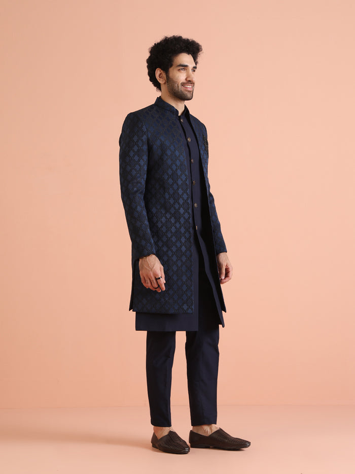 The side view of the model, walking gracefully in Kisah's Navy Blue Silk Blend Indo Western Sherwani trouser Set for men
