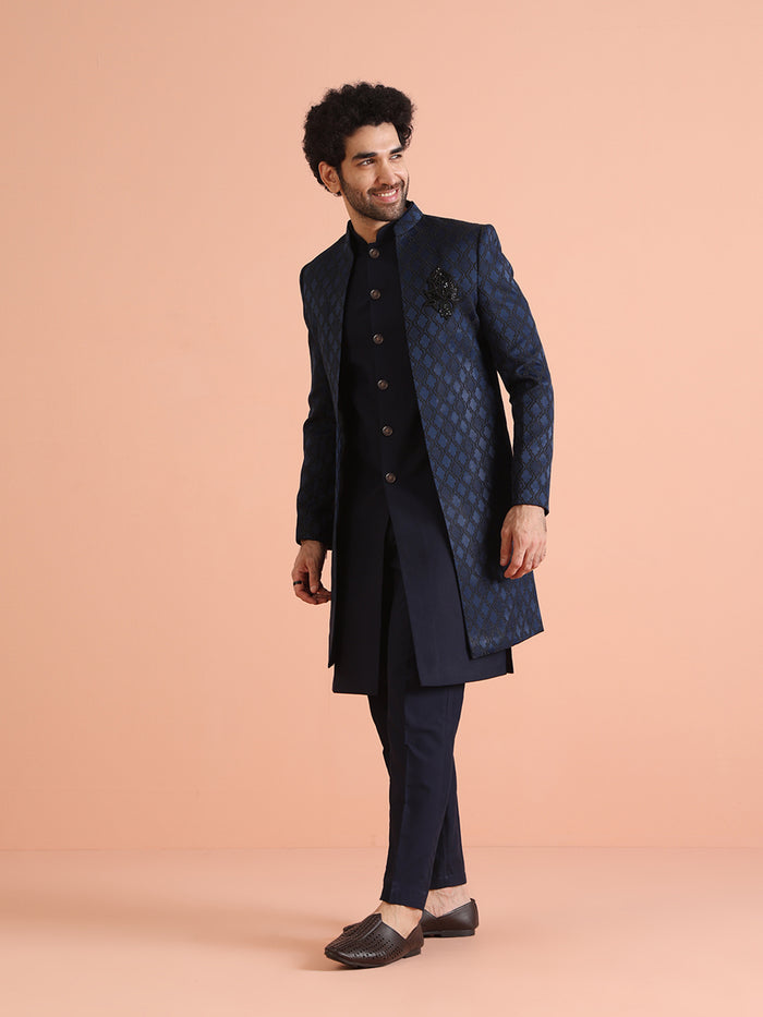 The model is seen from a side angle, posing in Kisah's Navy Blue Silk Blend Indo Western Sherwani Set for men