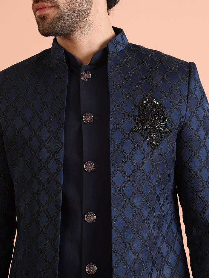 The close-up highlights the diamond quilted pattern and brooch detailing on Kisah's navy blue sherwani trouser set